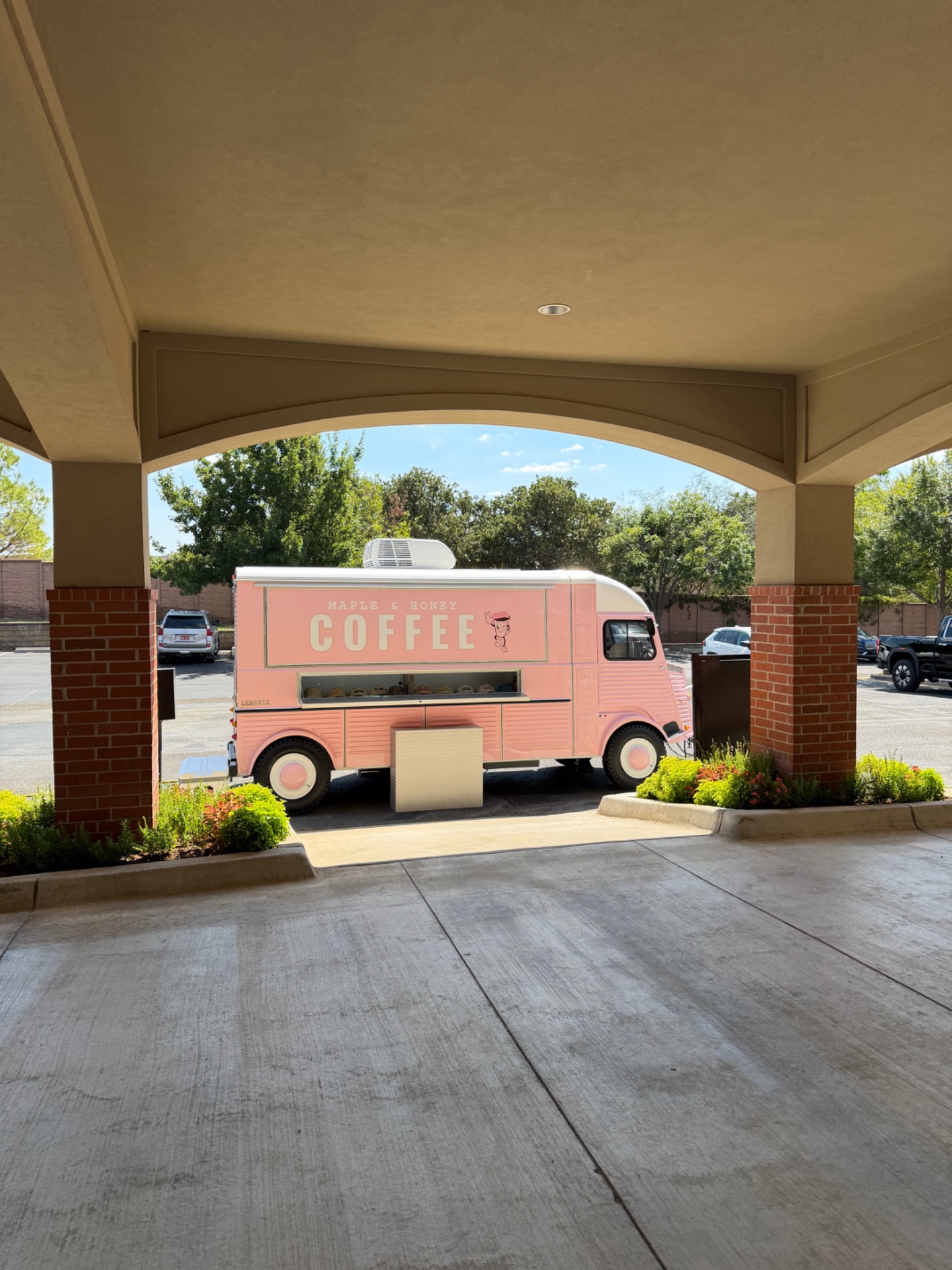 Pink Maple and Honey coffee trailer positioned outside a professional building
